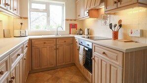A kitchen with wooden cabinets, a window, a toaster, and a kettle. - Tuliptree (Chesterfield)