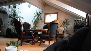 Un acogedor espacio tipo loft con zona de comedor, que incluye una mesa de madera, sillas y un sofá.