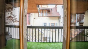 Un balcón con vistas a un patio y edificios cercanos.