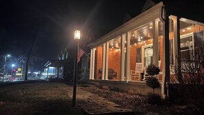 A house with a porch, a flag, and a street lamp.