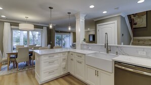 A modern kitchen with white cabinetry, a marble countertop, and a built-in dishwasher. - Sunset Rentals | Heritage Villas 2292 (Hilton Head Island)