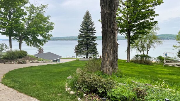 Un jardin bien entretenu, avec une pelouse, des arbres et une vue sur un lac.