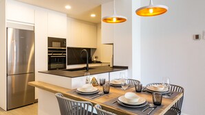 A modern kitchen with stainless steel appliances, a central island with seating, and pendant lighting. - Ref. 336889 (Motril)