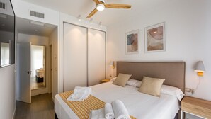 A hotel room with a bed, a ceiling fan, a bedside table with a lamp, and two framed artworks on the wall. - Ref. 336889 (Motril)