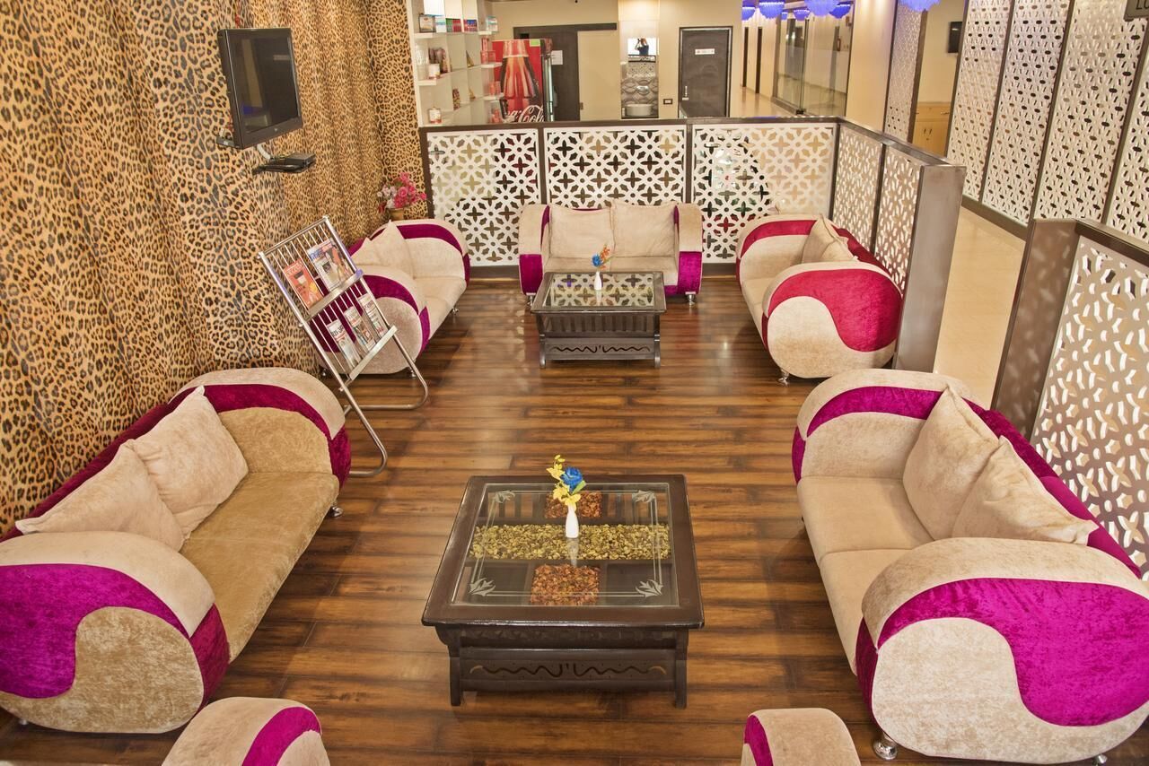 A hotel lobby with sofas, a coffee table, and a decorative screen.