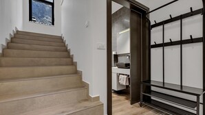 A staircase leading to a bathroom with a sink and towel rack.
