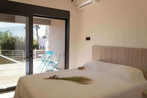 Una camera da letto con un letto, un comodino, una finestra e vista sull'esterno.