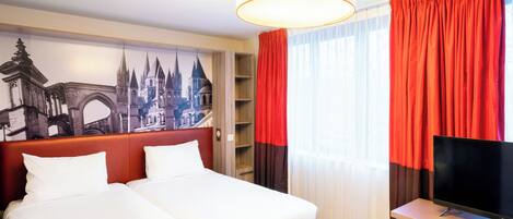 A hotel room with two beds, a TV, a large window with red curtains, and a mural of a cityscape.