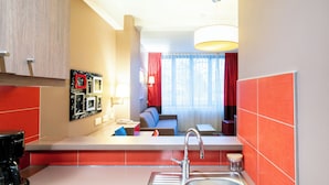 A compact hotel room with a kitchenette, a dining area, and a seating space. - B&B HOME Caen Centre Gare (Caen)