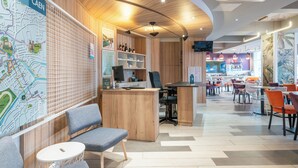 A modern interior with a reception desk, seating area, and a map on the wall. - B&B HOME Caen Centre Gare (Caen)