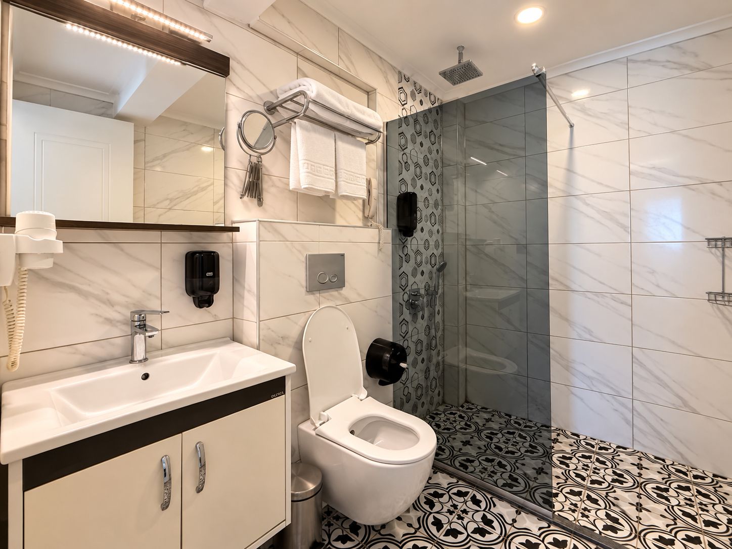 Un baño moderno con inodoro, lavabo y zona de ducha.