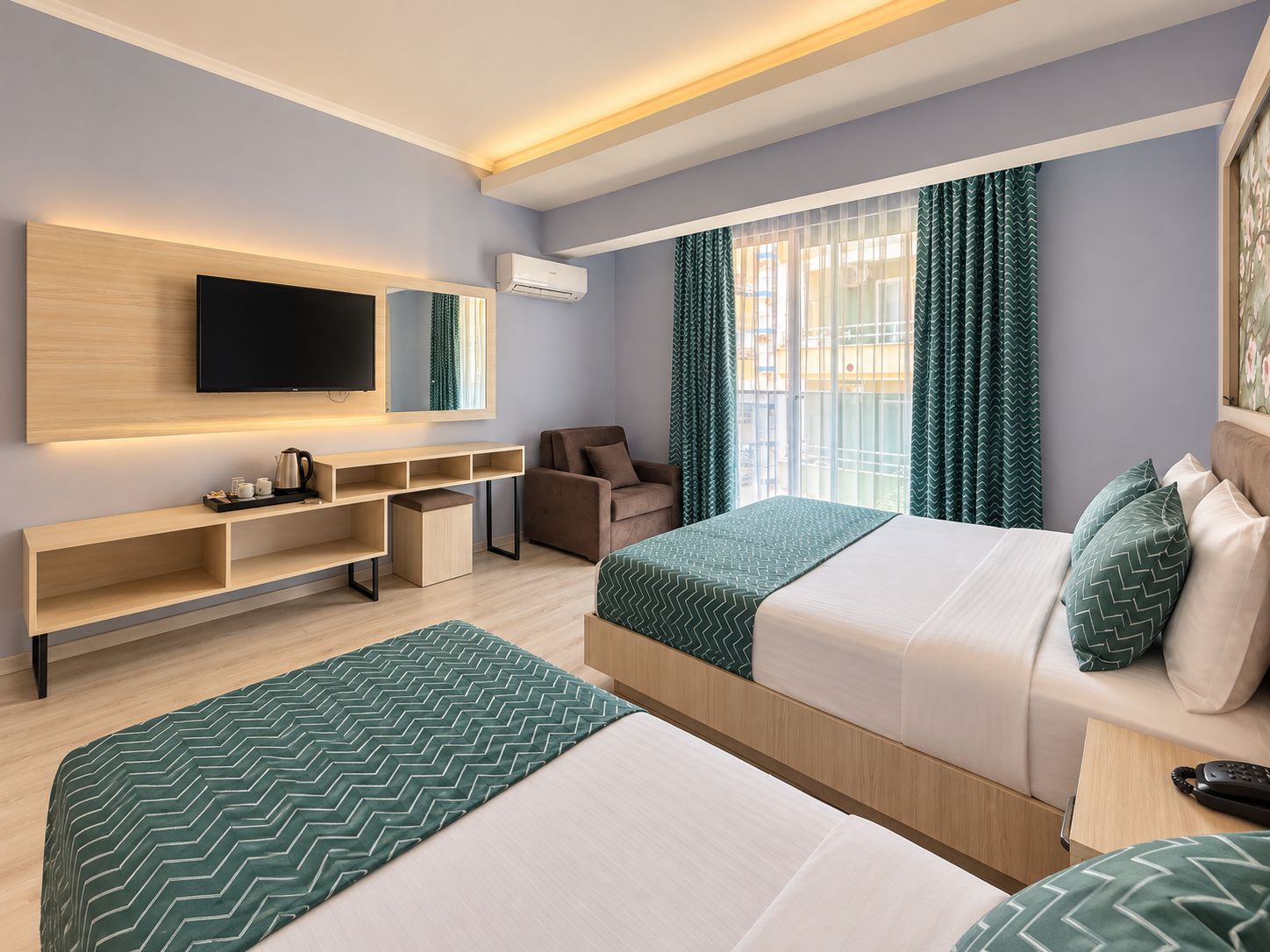 Una habitación de hotel con dos camas, televisión, escritorio y una silla.