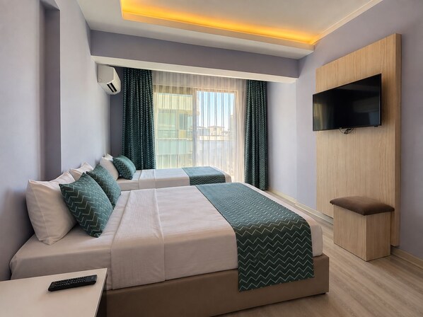 A hotel room with two beds, a TV, and a window with curtains. - Livaneli Boutique Otel (Alanya)