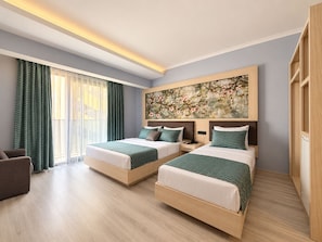 A hotel room with two beds, a large window with curtains, a painting on the wall, and a wooden floor. - Livaneli Boutique Otel (Alanya)