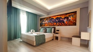 A modern bedroom with a bed, a nightstand, a bedside table, and a large painting on the wall. - Livaneli Boutique Otel (Alanya)
