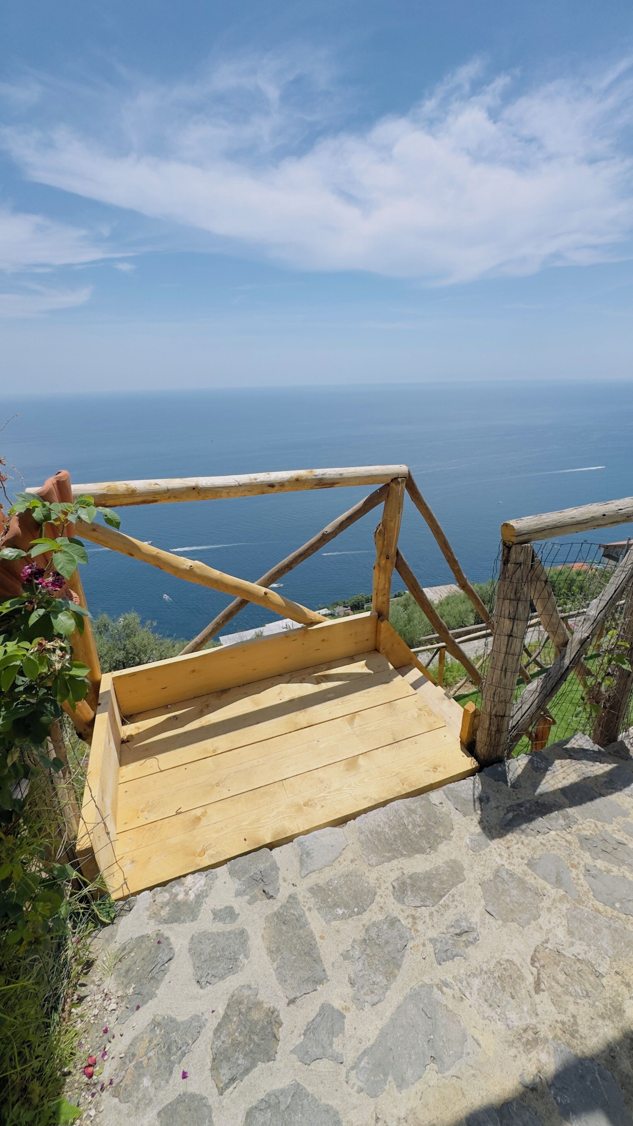 Una piattaforma panoramica in legno con gradini in pietra che conducono a un punto di vista mozzafiato.
