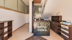 Uma receção de hotel com design moderno, uma escadaria e vista para o exterior.