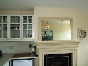 A kitchen with a built-in cabinet, a microwave, a knife set, and a clock on the wall.