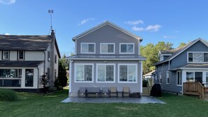 A two-story house with a front porch and a small deck.