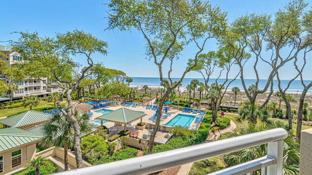 Et resort med flere swimmingpools, udsigt til stranden og velholdt have.