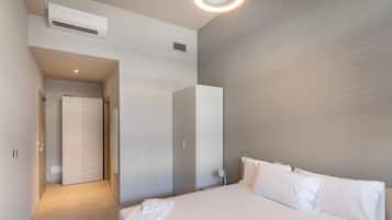 Una habitación de hotel moderna con una cama grande, un armario y un vestidor.