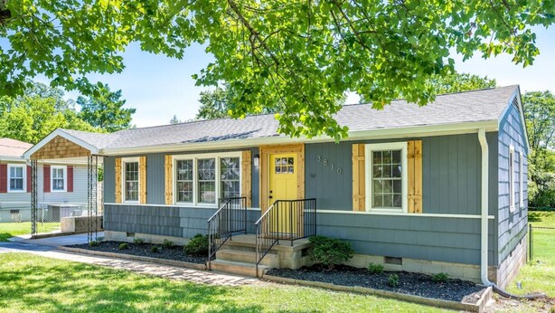 A single-story house with a front porch, a yellow door, and a mailbox. - Yellow Door Cottage - 3BR, Pet & family friendly! (Chattanooga)