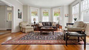 A living room with a large rug, two sofas, a coffee table, and a side table with a lamp. - Downtown Luxury | Rutledge Avenue Inn (Suite A) (Charleston)