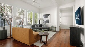 A modern living room with a sofa, coffee table, and a TV on the wall. - Luxurious Escape in Downtown Charleston | Apollo (Charleston)