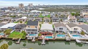 A residential area with houses, a marina, and a large body of water. - Channel Cat - Gorgeous Cherry Grove Channel House with Pool (North Myrtle Beach)