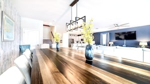 Ein moderner Essbereich mit Holztisch, Stühlen und einer Blumenvase.
