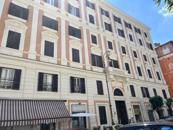 A multi-story building with a classic architectural style, featuring symmetrical windows and decorative moldings.