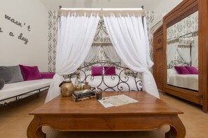 Um quarto com uma cama, uma mesa de madeira e um espelho.