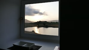A room with a large window overlooking a lake and distant mountains. - The Annexe at Loch View Farm will take your breath away (Crieff)
