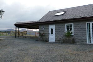 A stone building with a covered porch, a door, and windows. - The Annexe at Loch View Farm will take your breath away (Crieff)