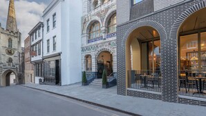 Un bâtiment historique doté d’une tour horlogée, d’une façade moderne en verre et d’une façade traditionnelle en briques.