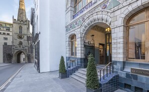 Ein historisches Gebäude mit einem Uhrturm, einem prunkvollen Eingang und einem Schild für das Clayton Hotel.