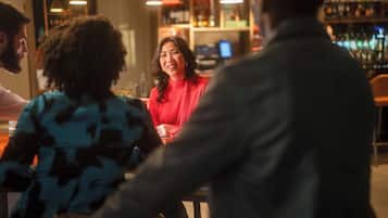 A bar setting with patrons seated around tables.