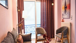 Ein Wohnzimmer mit einer Couch, zwei Sesseln, einem Couchtisch und einem Gemälde an der Wand.