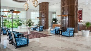 A spacious lobby with a reception desk, seating area with patterned chairs, and decorative wooden columns. - Mayan Palace Acapulco (Acapulco, Guerrero)