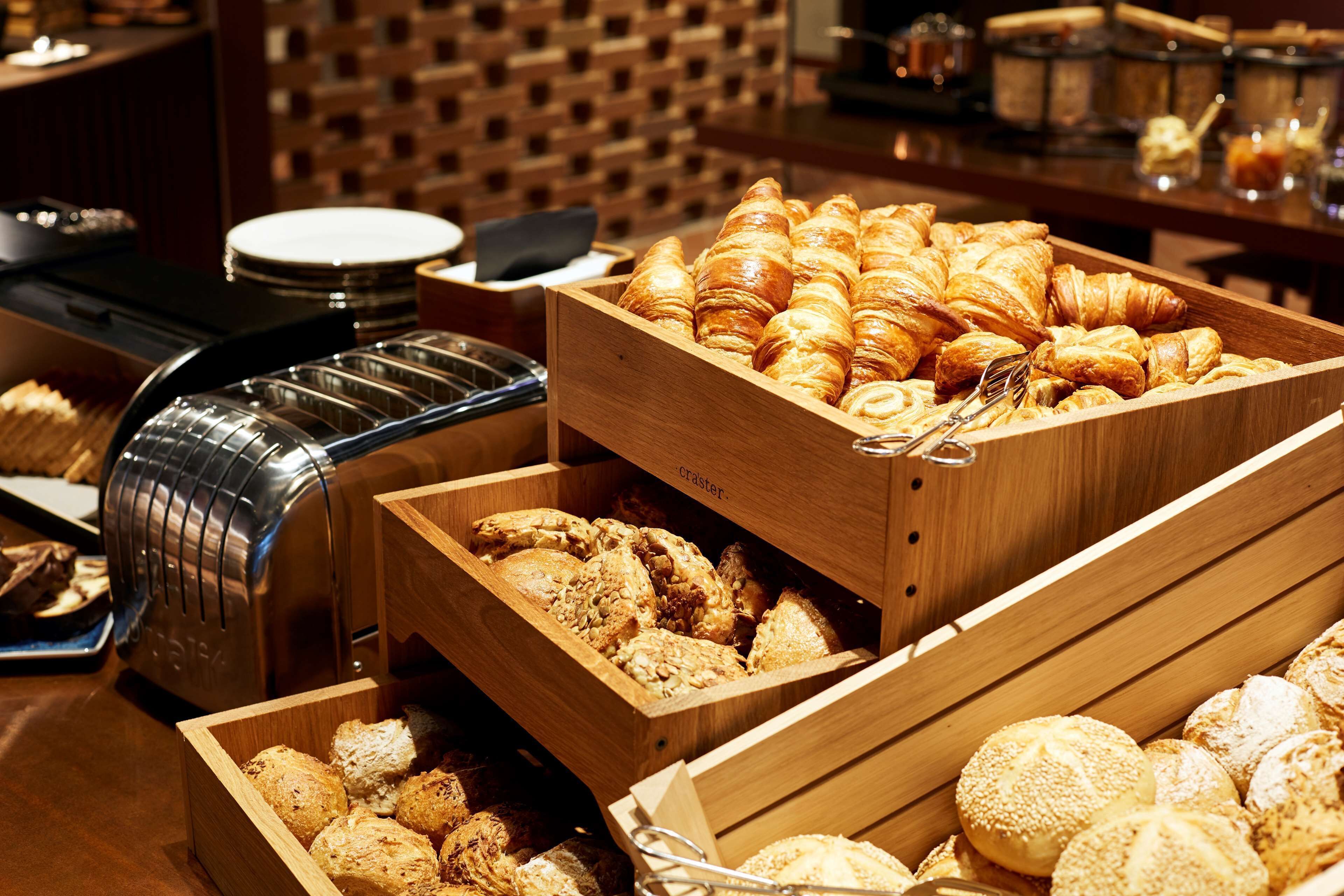 Un buffet proposant une variété de produits de boulangerie, notamment des croissants et des viennoiseries.