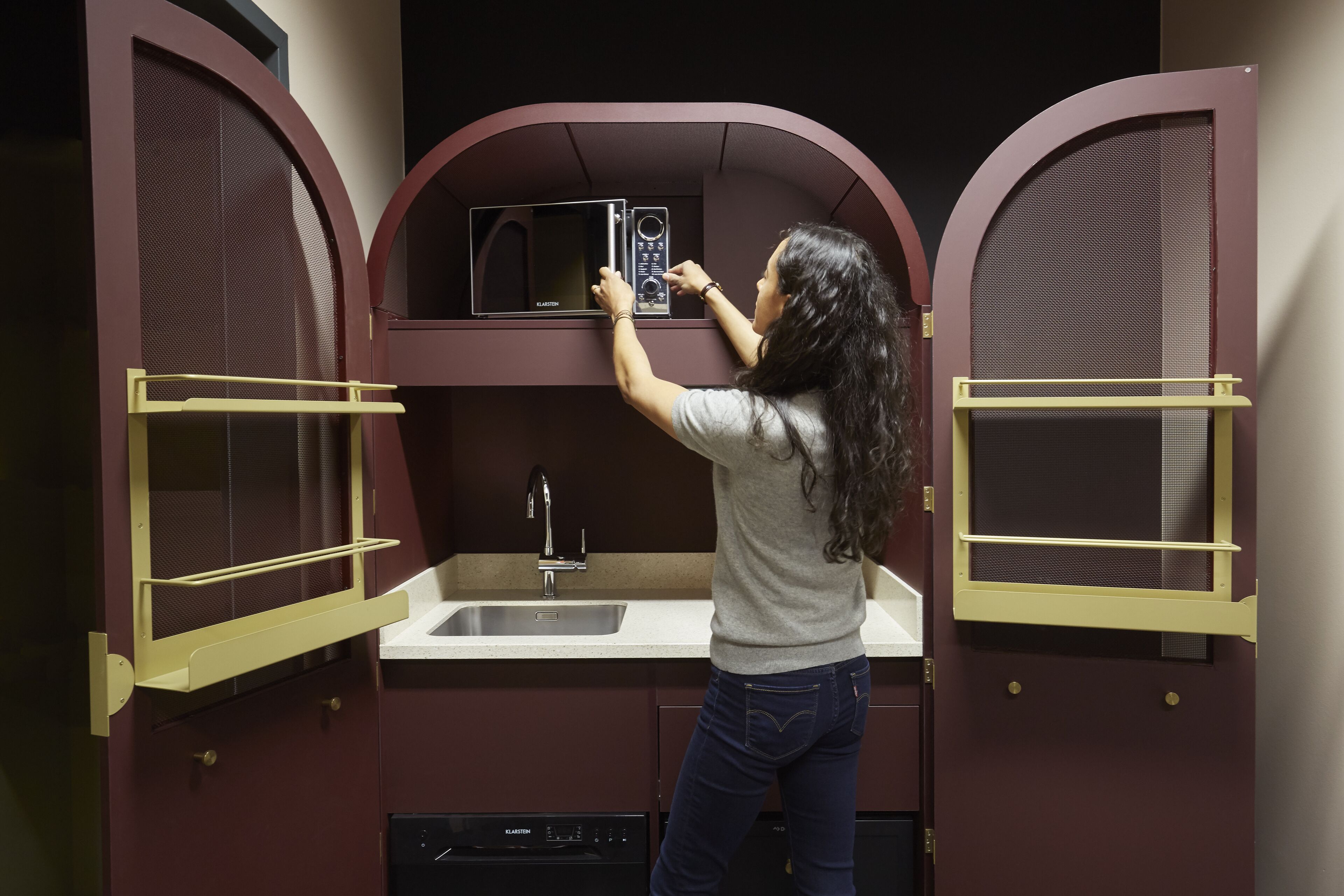 A compact kitchen with a microwave, sink, and dishwasher.