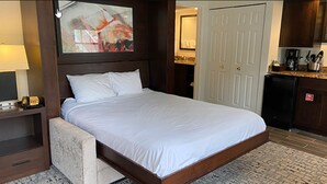 A hotel room with a bed, a desk with a lamp, a coffee maker, and a small refrigerator. - Enjoy the Scenery & Attractions of Branson! Sept 4th - 11th (Branson)