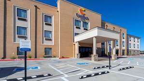 A Comfort Inn hotel with a brick facade, a covered entrance, and a parking lot with handicapped parking spaces.