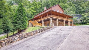 A large, two-story log cabin with a stone foundation and a wooden deck. - 44 Gathering Place (Hot Tub) 44 Golf View Rd: 6  BR, 4.5  BA Cabin / Bungalow in Maggie Valley, Sleeps 14 (Maggie Valley)