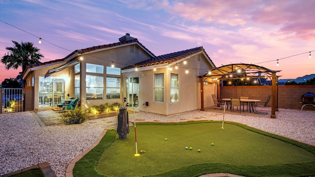 A house with a patio, a small lawn, and string lights.
