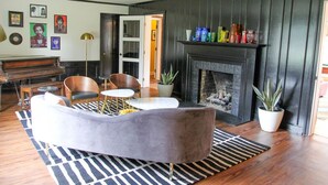 Un salon avec un piano, une cheminée et un aménagement moderne.