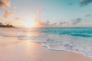 Ein Strand mit sanften Wellen und einem Sonnenuntergang.