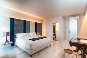 A modern hotel room with a large bed, a desk, and a mirror.