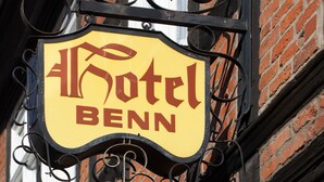 A hotel sign with the name "Hotel Benn" in a traditional font, mounted on a black metal bracket with decorative elements. - Hotel Benn (Berlin)