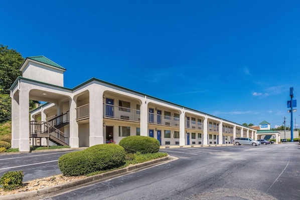 A motel with a central courtyard, multiple balconies, and a parking lot. - Rodeway Inn and Suites Macon (Macon)